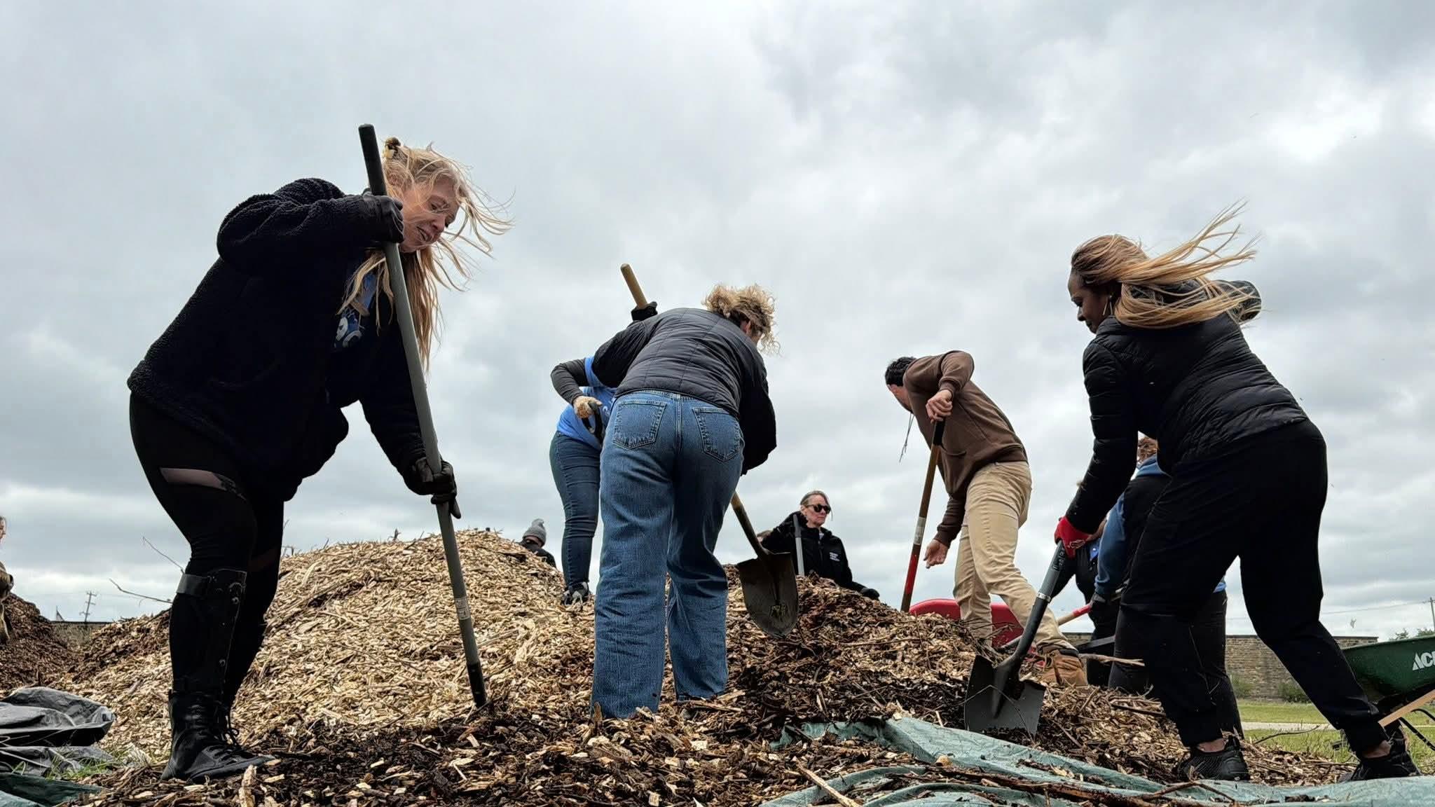 Community Impact Day volunteers shoveling mulch at Grow Jackson and River & Rail.