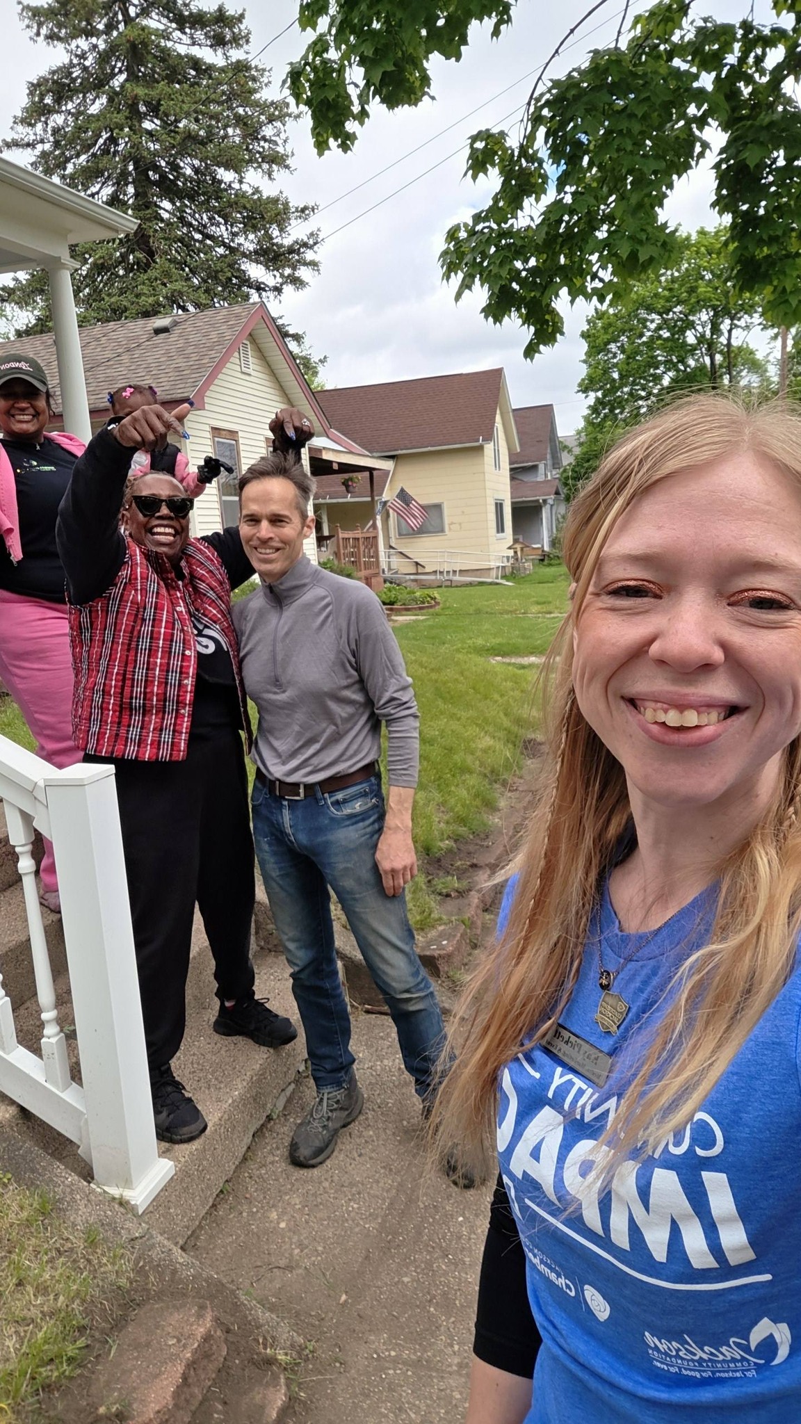 Kay taking a group selfie with fellow Community Impact Day participants outside Serenity Sober Living House.